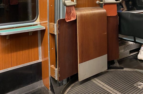 Detailaufnahme einer alten Straßenbahn von innen. Drehgestell und Fußboden sind zu sehen